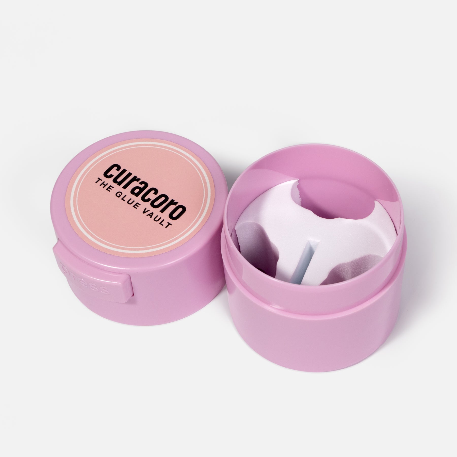 Pink Curacoro Glue Vault adhesive storage container with an open lid showing the inner compartment.