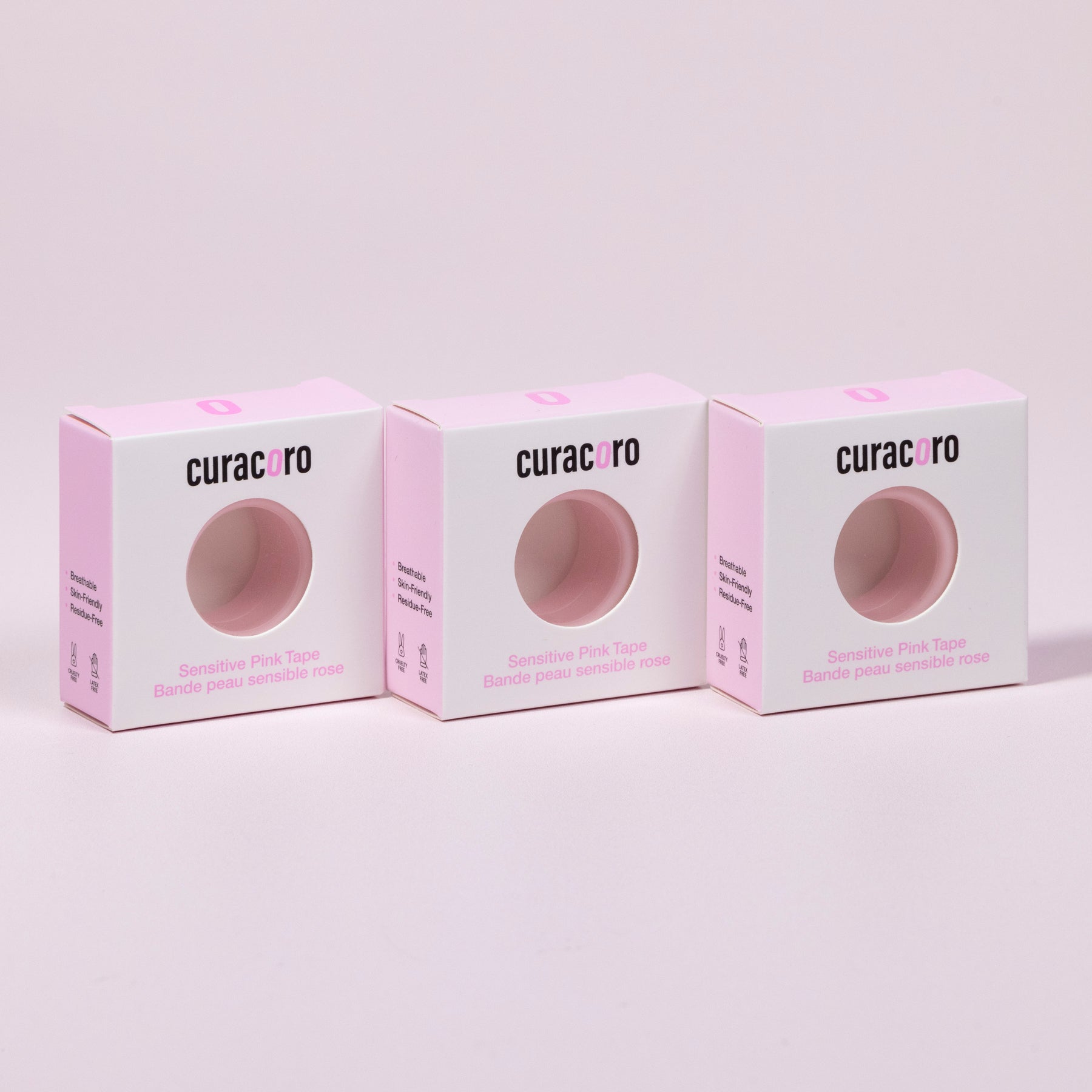 Curacoro sensitive pink tape for eyelash extensions, three boxes displayed in a row on soft pink background