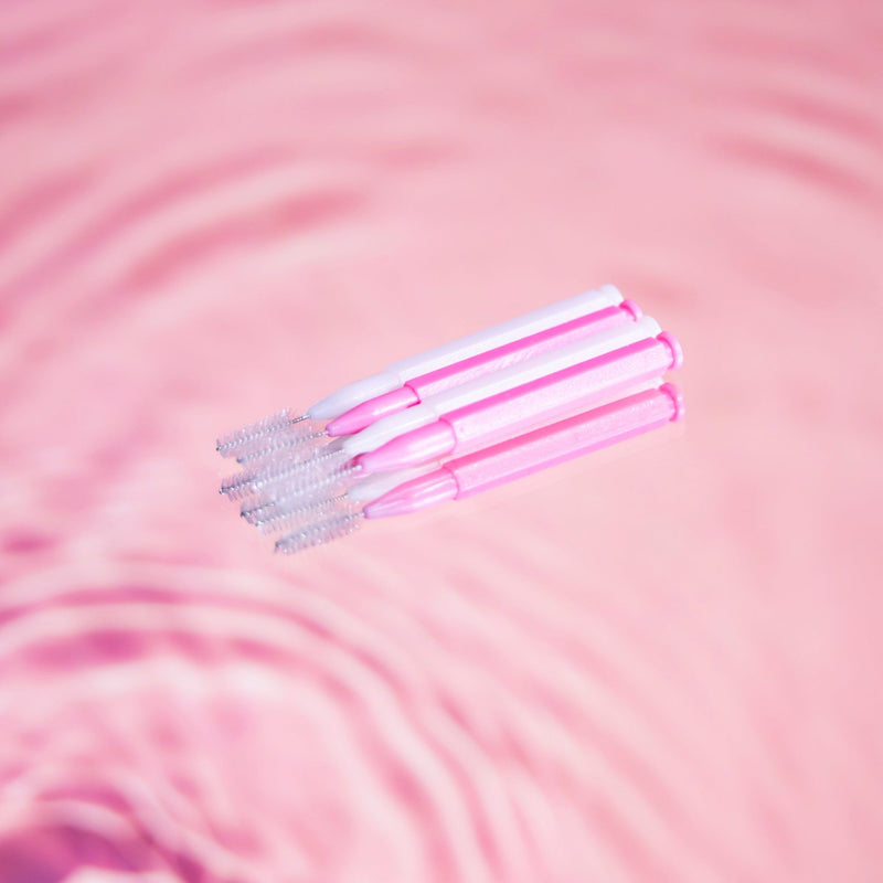 Brow Lamination Comb Brush pack in front of pink background.