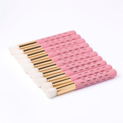 Pink wooden cleansing brushes over white background