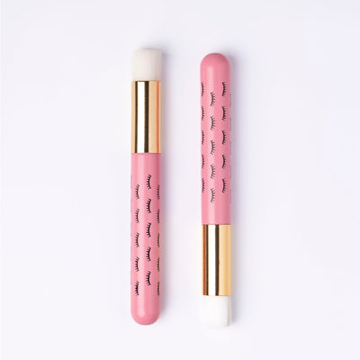 Two pink wooden cleansing brushes over white background