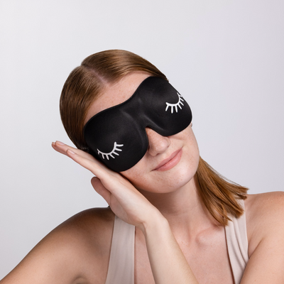 A model wearing a black 3D foam eye mask. 