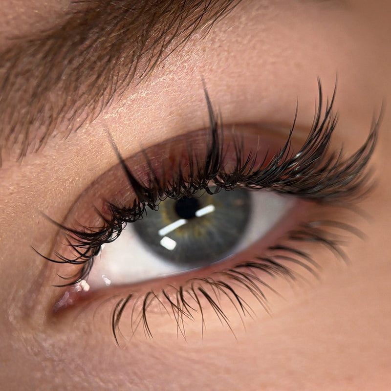 Close-up of a green eye with voluminous anime-style eyelash extensions.