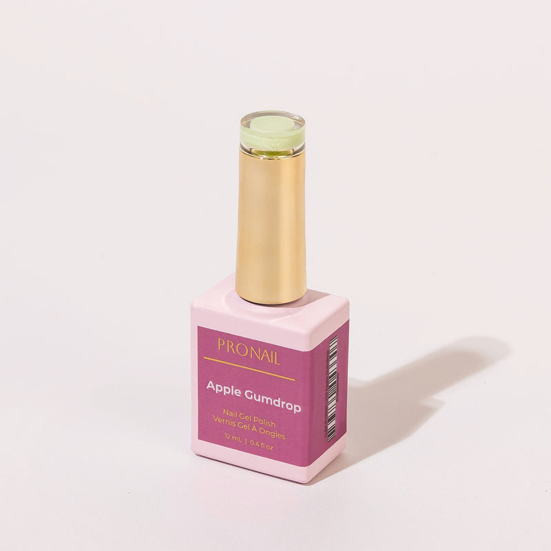 A Apple Gumdrop nail polish bottle with a gold cap casting a shadow on a white background.