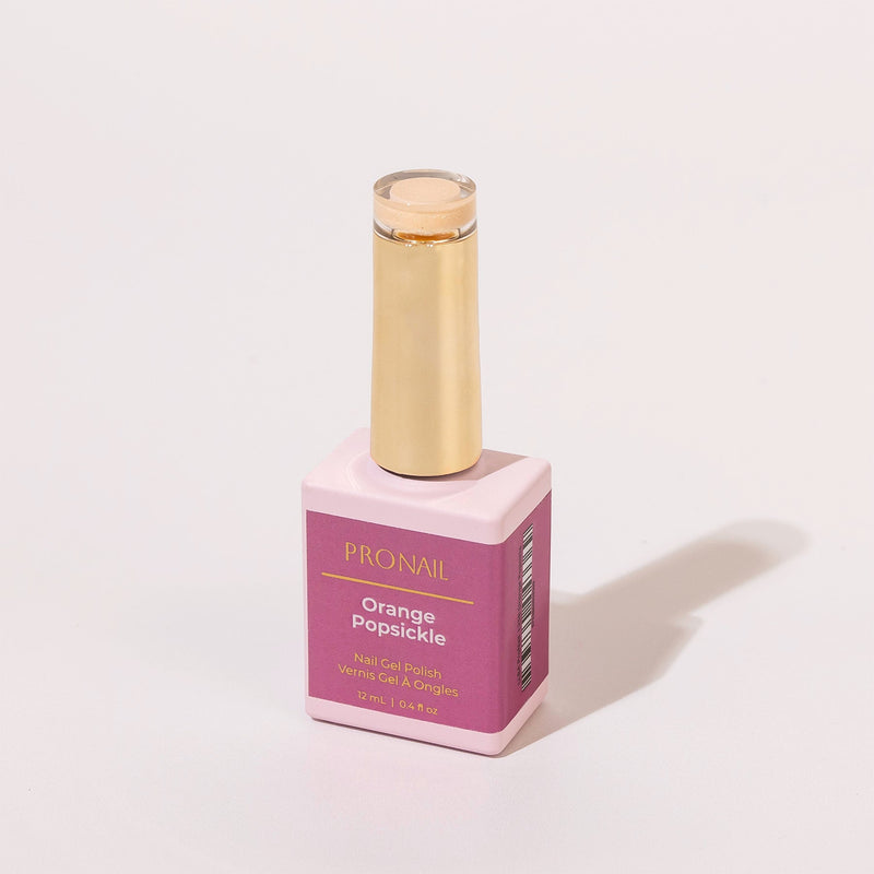 An Orange Popsickle nail polish bottle with a gold cap casting a shadow on a white background.