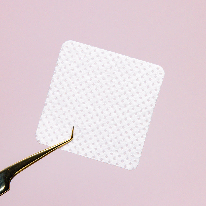 Adhesive Nozzle Wipe Close Up over a pink background. 