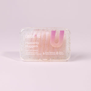 Curacoro Heavenly Huggers lash lift shields in a glittery transparent case containing 8 pairs of thick teardrop-shaped shields.
