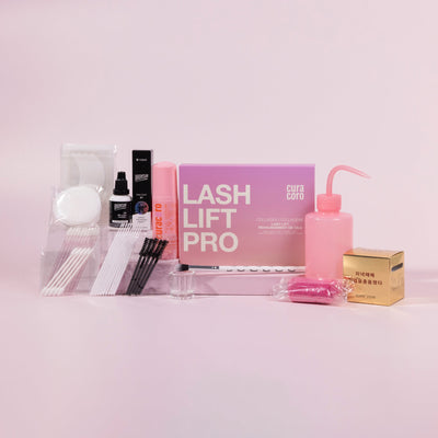 Curacoro Lash Lift Pro kit with tools and accessories for lash lifting and tinting on a pink background.