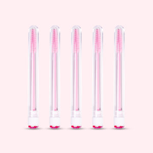 Five pcs Mascara Brushes with Tubes over a light pink background. 