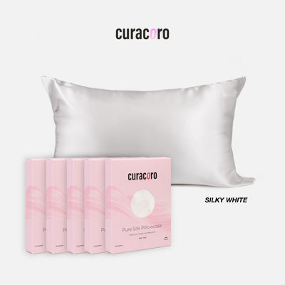 Curacoro Pure Silk Pillowcase in Himalayan silky white, displayed with multiple packaging boxes, showcasing its luxurious and smooth texture.