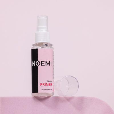 Noemi Brow Primer Bottle Over Pink Background