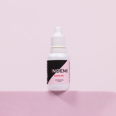 Noemi Solution 6% Bottle Over Pink Background