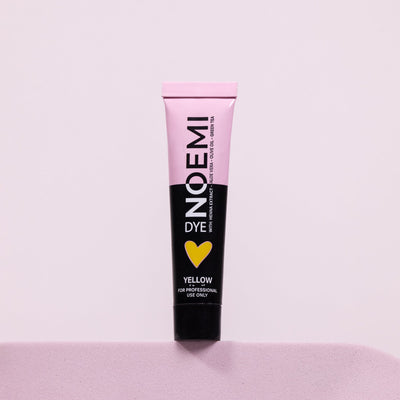 Noemi Hybrid Brow & Lash Dye - Yellow (Corrector) Bottle Over Pink Background