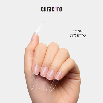 Curacoro long stiletto soft gel nail tips applied on a model’s hand, clear extensions with a sharp tapered shape