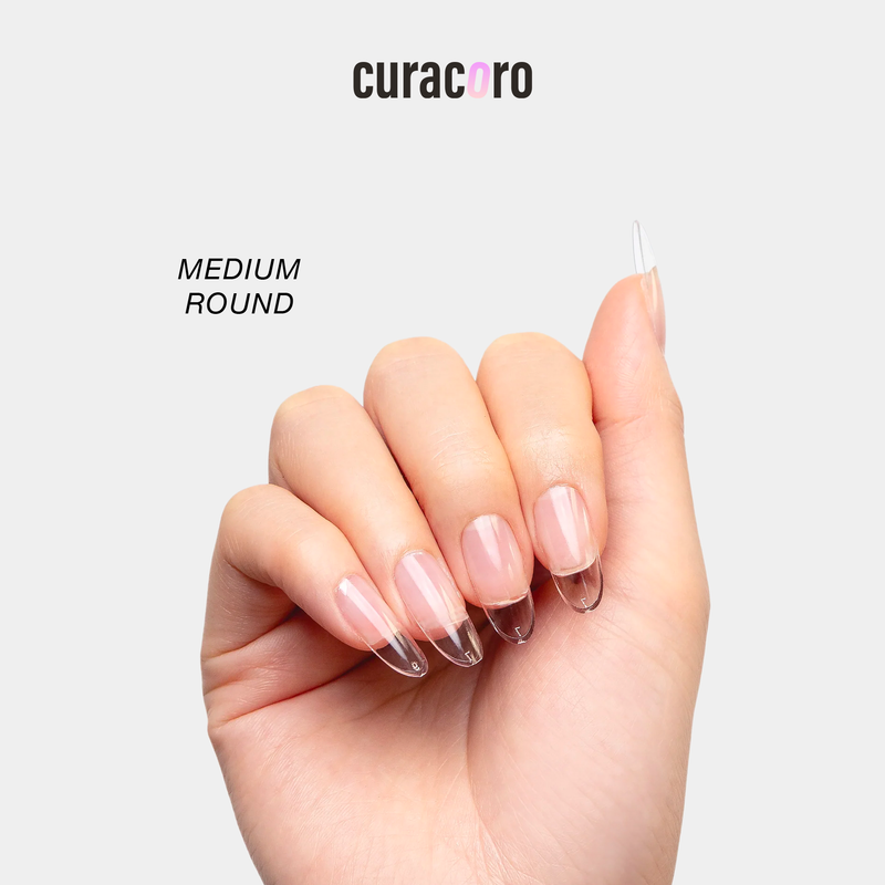 Curacoro soft gel nail tips in medium round shape, applied on hand, displayed against a white background