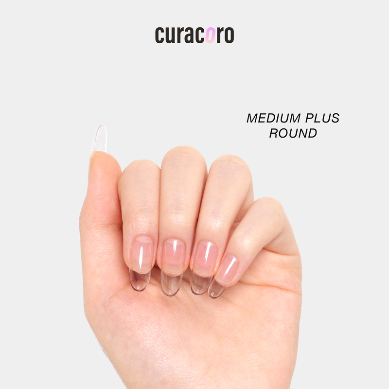 Curacoro soft gel nail tips in medium plus round shape, applied on hand, displayed against a white background