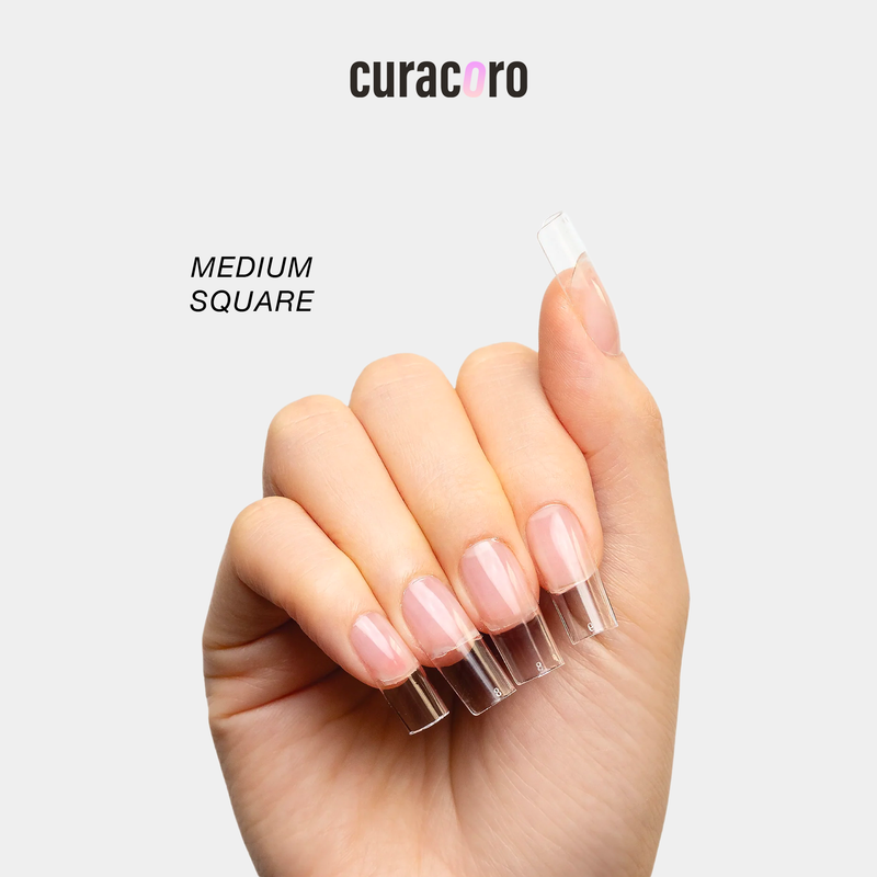 Curacoro soft gel nail tips in medium square shape, applied on hand, displayed against a white background