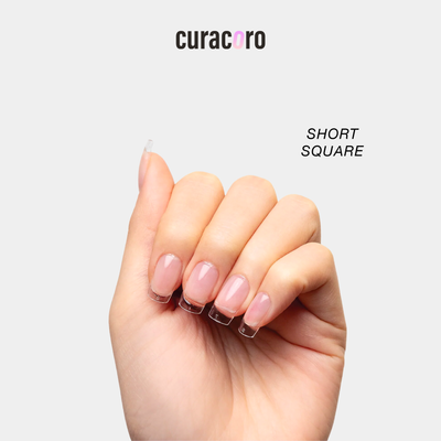 Curacoro soft gel nail tips in short square shape, applied on hand, displayed against a white background