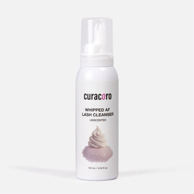 White bottle of curacoro whipped AF lash cleanser on a white background