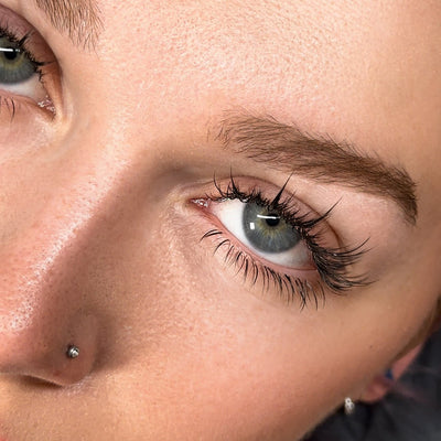 A model's eye with anime-inspired lash extensions, emphasizing a natural yet dramatic curl and volume.