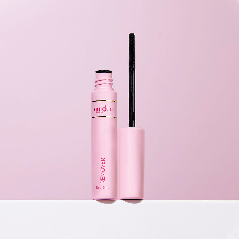 Pink tube of Quickie by LLBA Remover, 5 mL, displayed with the wand applicator open against a matching soft pink background.