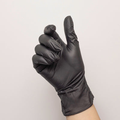 Black disposable glove on model's hand.