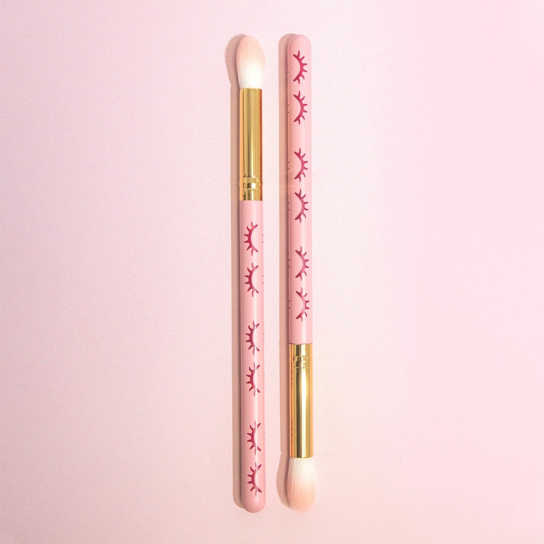 Two Pink Cleansing Brush in front of a pink background.