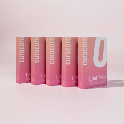 Five Lashfolio boxes displayed in a neat row against a soft pink background, showcasing the premium lash collection.