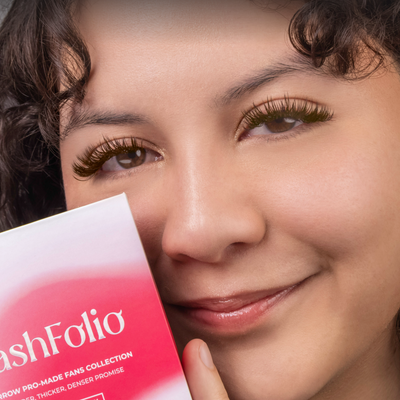 Smiling woman showcasing Curacoro LashFolio with long, voluminous eyelash extensions.