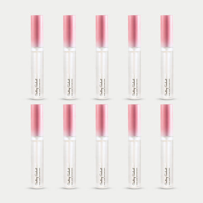 ten bottles of Curacoro Coating Sealant for lash extensions, featuring a sleek design with a gradient pink cap.