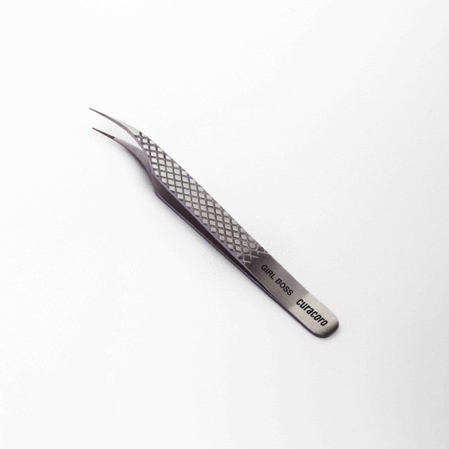 Curacoro "Girl Boss" eyelash extension tweezer with a textured grip design, displayed on a white background.