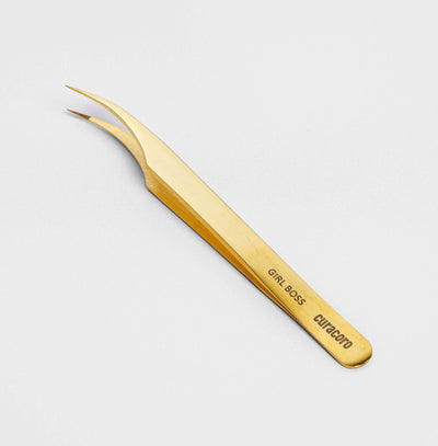 Girl Boss Tweezer Gold over a light background. 