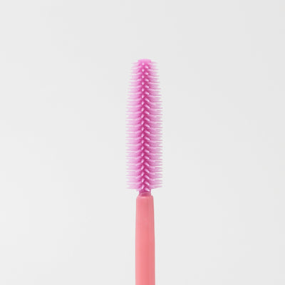 Image of the texture of a disposable pink silicon brush wands for eyelashes and brows.