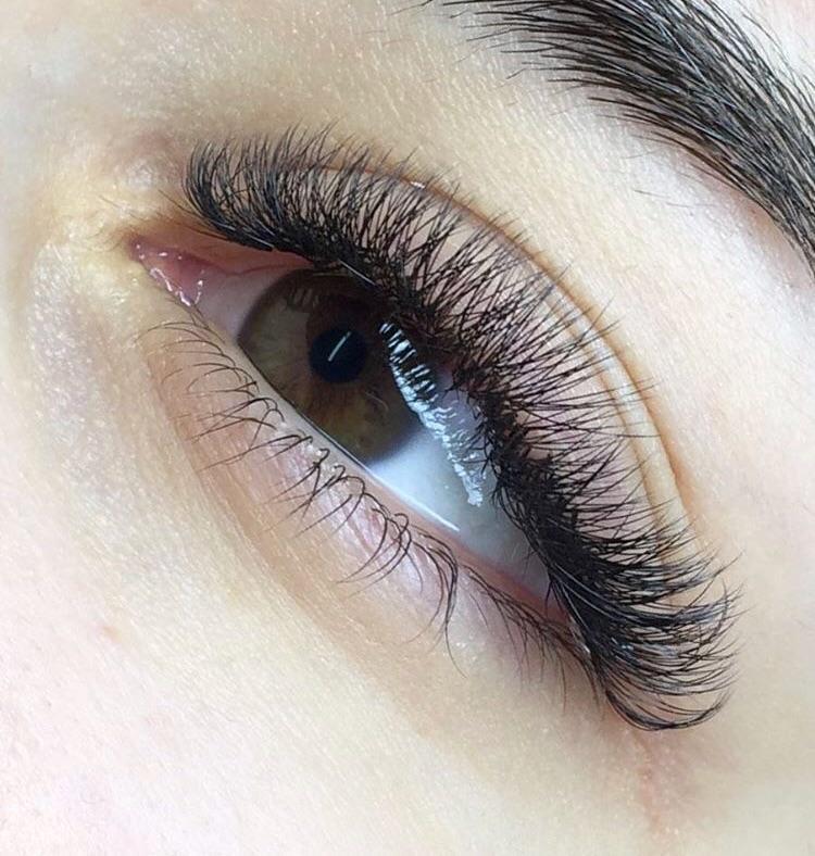 Close-up of an eye with full, voluminous eyelash extensions, showcasing professional lash application.