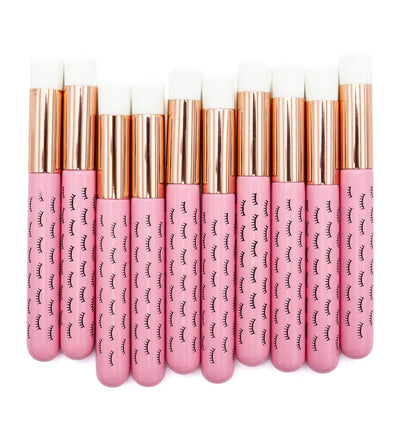 Pink wooden cleansing brushes over white background